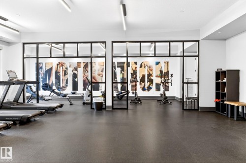Dedicated fitness room featuring dark rubber flooring and white walls - 520 7463 May Common, Edmonton, AB - Indoor Photo Showing Gym Room