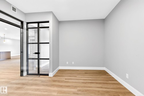 Room featuring light wood-finish flooring, crisp white baseboards, and light gray walls - 520 7463 May Common, Edmonton, AB - Indoor Photo Showing Other Room
