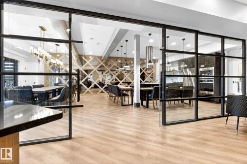 Glass paneled sliding doors opening to an expansive interior space with light wood-finish flooring - 520 7463 May Common, Edmonton, AB - Indoor