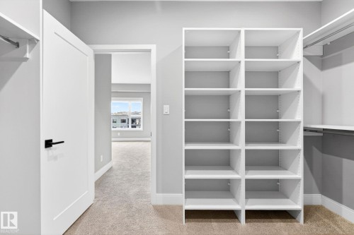 White built-in shelving with adjustable shelves and a hanging rod system - 520 7463 May Common, Edmonton, AB - Indoor With Storage
