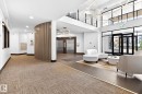 Spacious lobby featuring high ceilings, contemporary light fixtures, a multi-level layout, and large glass entry doors - 520 7463 May Common, Edmonton, AB  - Indoor Photo Showing Other Room 