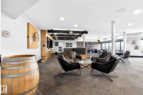Open-concept common area featuring recessed lighting, a built-in wall unit, and a coffered ceiling detail - 520 7463 May Common, Edmonton, AB - Indoor