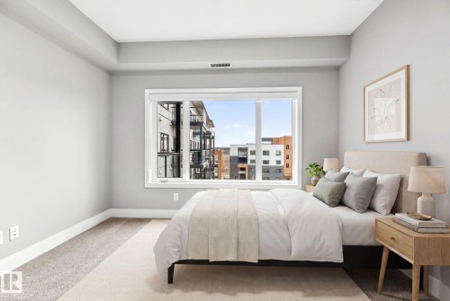 Spacious room featuring light gray walls, plush carpeting, a large window, white trim, and a high ceiling - 520 7463 May Common, Edmonton, AB - Indoor Photo Showing Bedroom