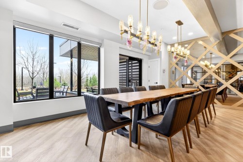 Dining area featuring light wood-finish flooring and a full wall of floor-to-ceiling windows - 520 7463 May Common, Edmonton, AB - Indoor Photo Showing Dining Room