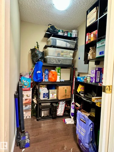Interior storage area featuring a light-colored ceiling, light wall paint, and wood-finish flooring - 211 9619 174 Street, Edmonton, AB - Indoor