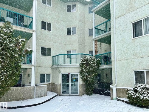 Multi-story residential building with textured pale green stucco exterior - 211 9619 174 Street, Edmonton, AB - Outdoor With Balcony With Exterior