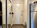 Entryway featuring wood-finish flooring and a full-length mirrored closet - 211 9619 174 Street, Edmonton, AB  - Indoor Photo Showing Other Room 