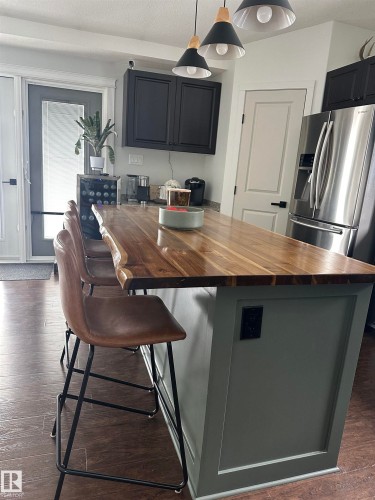 Kitchen island featuring a live-edge wood countertop and paneled base - 4926 58 Ave, Cold Lake, AB - Indoor