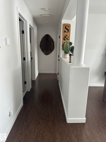 Hallway featuring dark wood-finish flooring, white walls, and white trim - 4926 58 Ave, Cold Lake, AB - Indoor Photo Showing Other Room