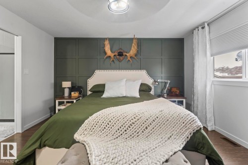 Bedroom featuring a paneled accent wall, wood-finish flooring, recessed lighting, and a window with blinds - 4926 58 Ave, Cold Lake, AB - Indoor Photo Showing Bedroom