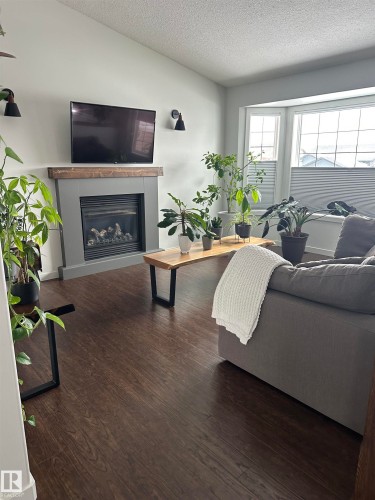 Living area featuring a gas fireplace with a wood-finish mantel and integrated accent lighting - 4926 58 Ave, Cold Lake, AB - Indoor Photo Showing Living Room With Fireplace