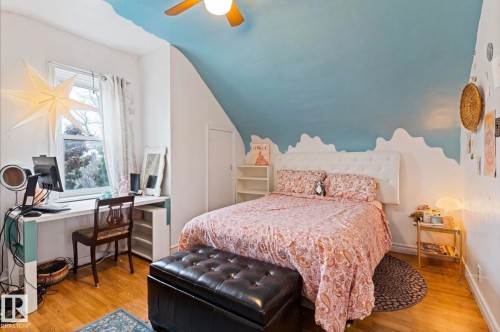 Bedroom featuring wood-finish flooring, a pitched ceiling, and a built-in desk area - 7703 77 Avenue, Edmonton, AB 