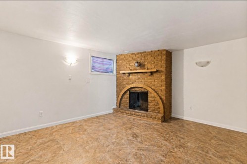 Brick fireplace with arched hearth and wood mantel - 7703 77 Avenue, Edmonton, AB 