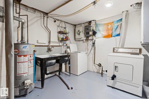 Utility area featuring a water heater, double basin utility sink, and ample space for laundry appliances - 7703 77 Avenue, Edmonton, AB 