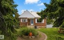 Brick facade residence featuring a white metal roof and a prominent front gable - 7703 77 Avenue, Edmonton, AB 