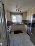 Kitchen featuring cream-colored cabinetry, laminate countertops, and a tile backsplash - 