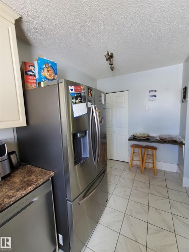 Stainless steel French door refrigerator with ice and water dispenser, complemented by a coordinating stainless steel dishwasher - 11814 157 Avenue, Edmonton, AB - Indoor Photo Showing Laundry Room