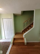 Hardwood flooring in main living area with a two-step transition to the tiled entryway - 