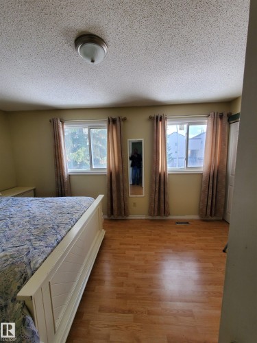 Spacious room featuring wood-finish flooring and two large windows with valances - 11814 157 Avenue, Edmonton, AB - Indoor Photo Showing Bedroom