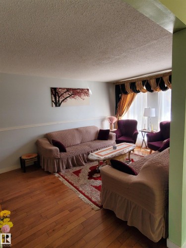 Wood-finish flooring creates a warm ambiance in this living space - 11814 157 Avenue, Edmonton, AB - Indoor Photo Showing Other Room