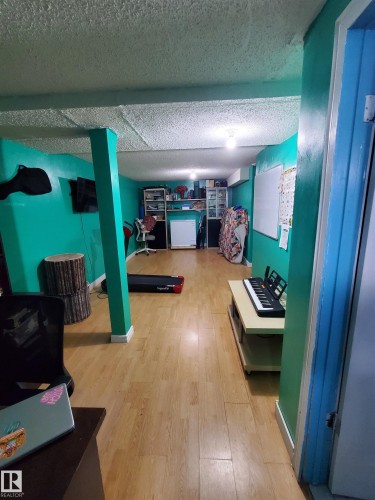 Spacious interior room featuring wood-finish flooring, recessed lighting, and support columns - 11814 157 Avenue, Edmonton, AB - Indoor Photo Showing Other Room