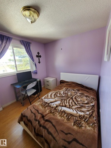 Room featuring wood-finish flooring and a window with white trim - 11814 157 Avenue, Edmonton, AB - Indoor Photo Showing Bedroom