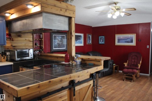 Open-concept kitchen and living area featuring wood-finish flooring - 4839 49 Avenue, Chipman, AB - Indoor