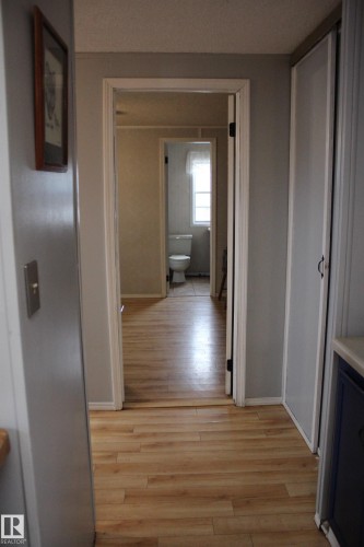Hallway featuring wood-finish flooring, light gray wall paint, and white trim - 4839 49 Avenue, Chipman, AB - Indoor Photo Showing Other Room