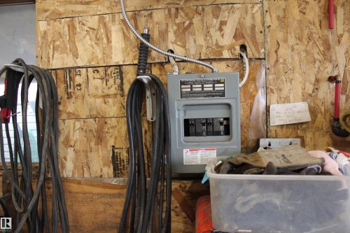 Electrical service panel mounted on an oriented strand board wall - 4839 49 Avenue, Chipman, AB - Indoor Photo Showing Basement