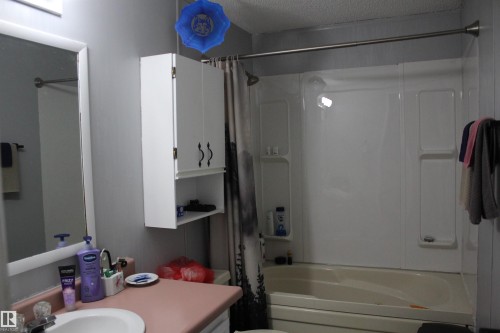 Bathroom featuring a white bathtub, integrated shower surround, and overhead light fixture - 4839 49 Avenue, Chipman, AB - Indoor Photo Showing Bathroom