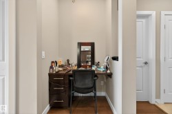 Dedicated nook featuring a dark wood-finish vanity with drawer storage, a wall-mounted shelf, and wood-finish flooring - 