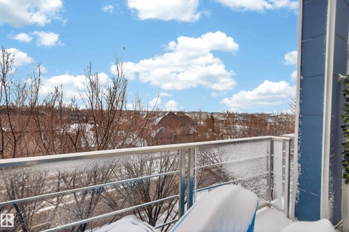 Balcony with a clear glass and metal railing, offering broad neighborhood scenery - 409 2584 Anderson Way, Edmonton, AB - Outdoor With Balcony