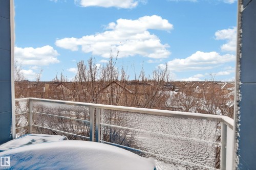 Balcony featuring a metal railing and a partial view of residential rooftops - 409 2584 Anderson Way, Edmonton, AB - Outdoor