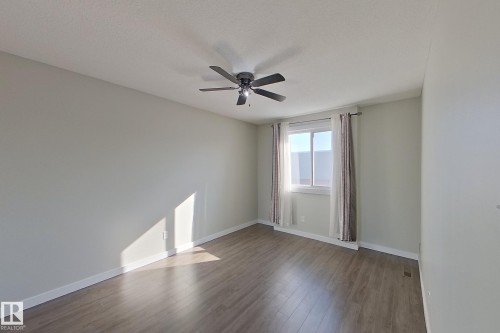This room features light-colored walls, a ceiling fan, and a window with white and patterned curtains - 184 Cornell Court, Edmonton, AB - Indoor Photo Showing Other Room