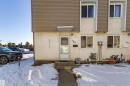 The property features a white stucco exterior with brown siding, a white front entry door, and white framed windows - 184 Cornell Court, Edmonton, AB  - Outdoor 