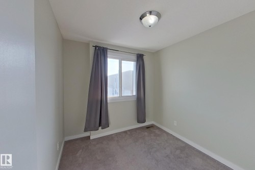 The room features light-colored walls, carpeted flooring, and a window with curtains - 184 Cornell Court, Edmonton, AB - Indoor Photo Showing Other Room