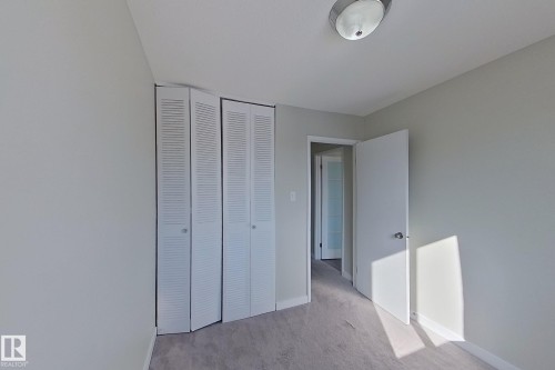 This room features light grey walls, grey flooring, and white bi-fold closet doors - 184 Cornell Court, Edmonton, AB - Indoor