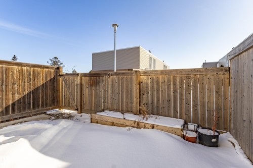 The property features a fenced yard with a wooden privacy fence and a gate - 184 Cornell Court, Edmonton, AB - Outdoor With Exterior
