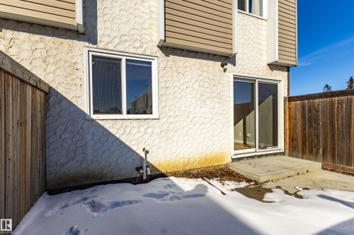 This property features an exterior with textured stucco and horizontal siding, along with a window and glass sliding door - 184 Cornell Court, Edmonton, AB - Outdoor With Exterior