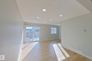 This bright living space features hardwood floors, recessed lighting, and a sliding glass door leading to an outdoor area - 184 Cornell Court, Edmonton, AB  - Indoor Photo Showing Other Room 