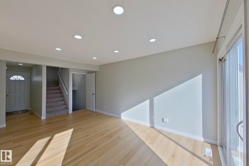 This bright living space features light wood flooring, recessed lighting, and a sliding glass door providing natural light - 184 Cornell Court, Edmonton, AB - Indoor Photo Showing Other Room