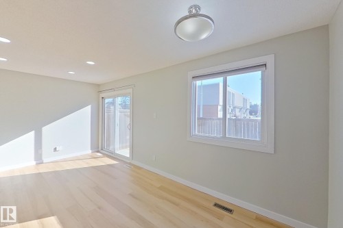 This bright room features light-toned flooring, a sliding glass door, a window, and recessed lighting in the ceiling - 184 Cornell Court, Edmonton, AB - Indoor Photo Showing Other Room