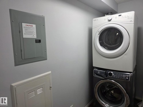 Dedicated laundry area featuring a stacked washer and dryer unit - 310 12045 22 Avenue, Edmonton, AB 