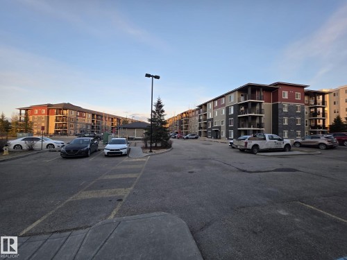 Multi-story residential buildings featuring varied siding, balconies, and an established parking area - 310 12045 22 Avenue, Edmonton, AB 