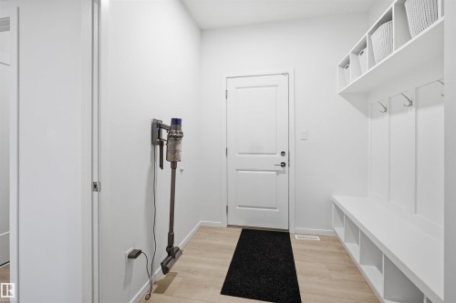 Entryway mudroom featuring built-in white shelving, integrated bench seating with open cubbies, and coat hooks - 7782 174A Avenue, Edmonton, AB - Indoor Photo Showing Other Room
