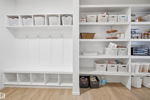 Built-in storage solutions featuring white shelving, coat hooks, and integrated cubbies - 7782 174A Avenue, Edmonton, AB - Indoor