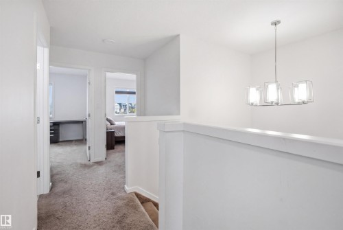 Upper-level landing featuring a contemporary chandelier with clear glass shades - 7782 174A Avenue, Edmonton, AB - Indoor Photo Showing Other Room