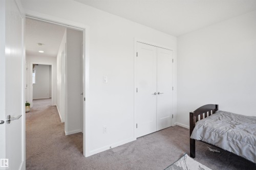 Carpeted room with white walls, baseboards, and a double-door closet - 7782 174A Avenue, Edmonton, AB - Indoor Photo Showing Bedroom