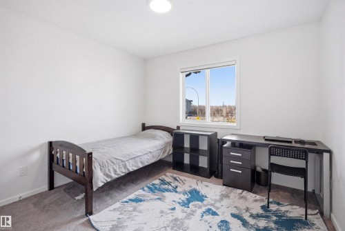 Bright interior room featuring a window with a white frame, light-colored walls, and gray carpet flooring - 7782 174A Avenue, Edmonton, AB - Indoor Photo Showing Bedroom