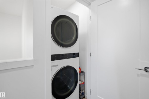 White stacked laundry appliances within a dedicated utility space - 7782 174A Avenue, Edmonton, AB - Indoor Photo Showing Laundry Room
